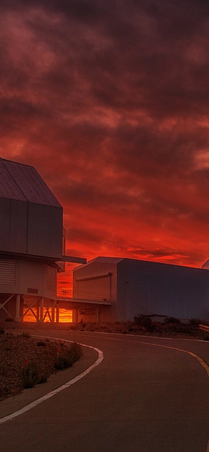 Sunset reddens the sky behind the Magellan telescopes at Carnegie's Las Campanas Observatory in Chile.