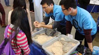 Attendees at the USA Science & Engineering Festival hunt for fossilized shark's teeth at the Carnegie booth