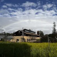 Department of Global Ecology building and greenhouses with a rainbow overhead.