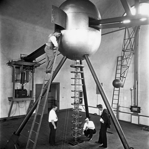 Odd Dahl (on ladder), Calvin F. Brown, Lawrence R. Hafstad, and Merle A. Tuve with two-meter electrostatic generator and cascade high-voltage tube.