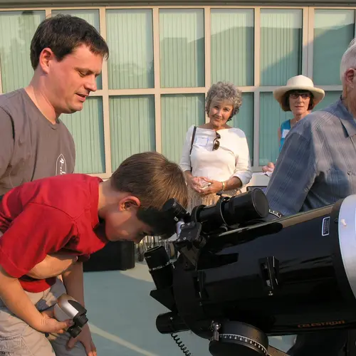 A young Open House attendee looks through a telescope