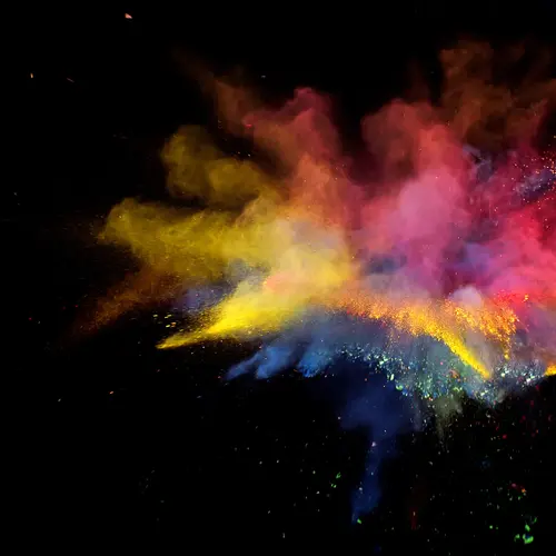 An explosion of rainbow powders on a black background